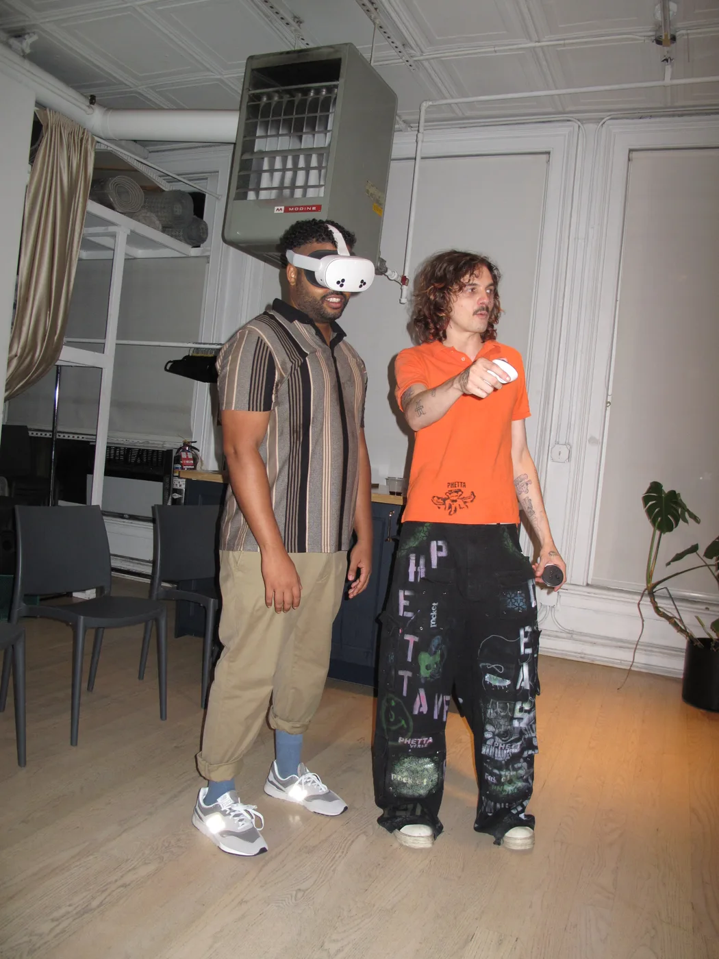 A guest wearing a VR headset beside another person holding a microphone