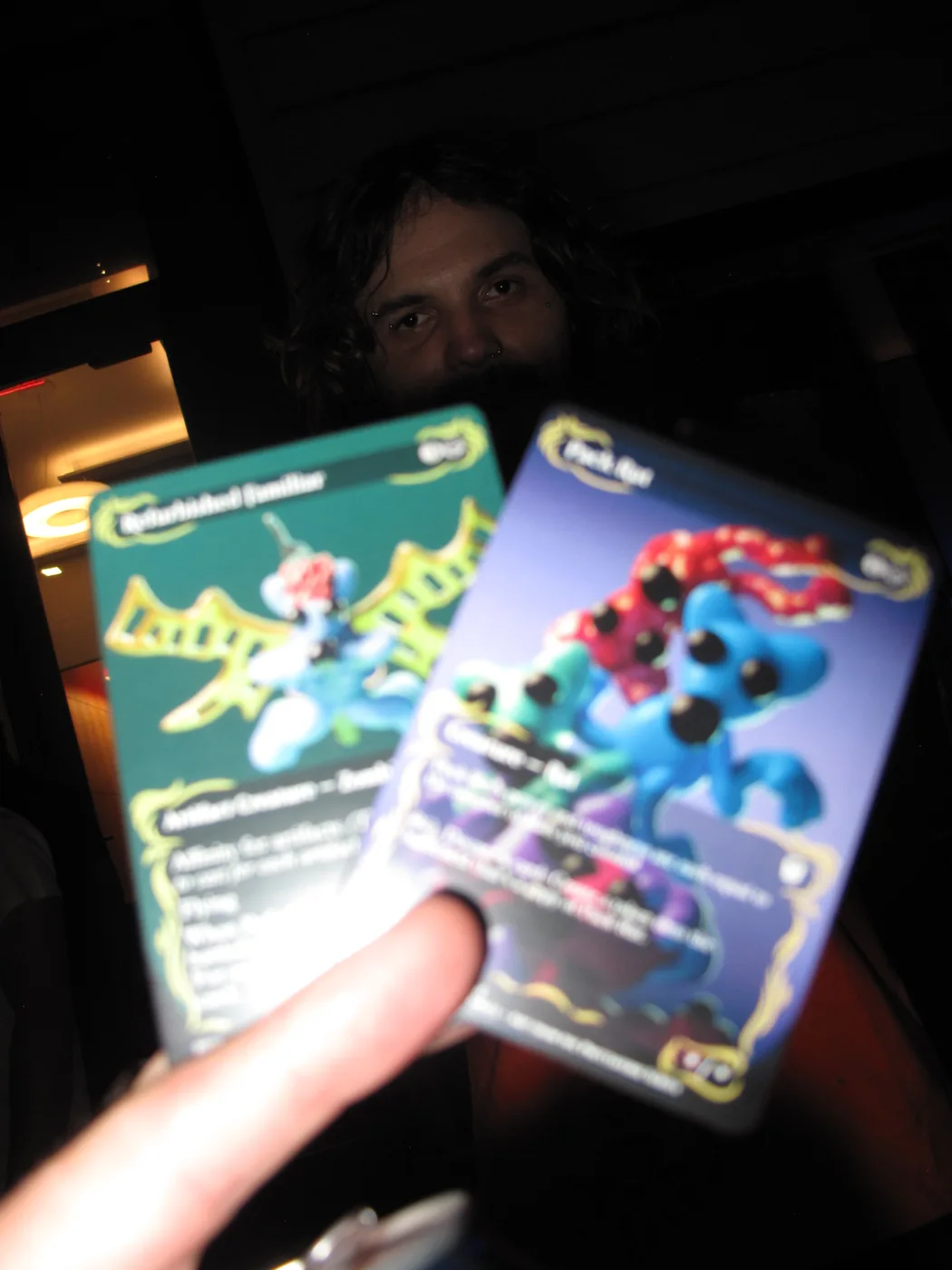 Two artist-designed cards held in a guest’s hand at the Burrito event